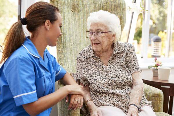 senior woman sitting in chair and talking